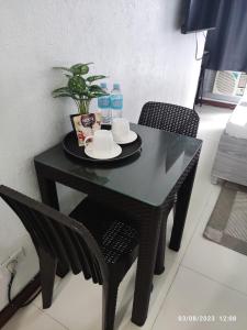un tavolo nero con due sedie e due bottiglie d'acqua di Citadel Inn a Manila