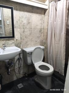 a bathroom with a white toilet and a sink at Citadel Inn in Manila