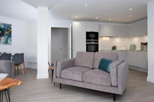 a living room with a couch and a kitchen at 1 Rockham - Luxury Apartment at Byron Woolacombe, only 4 minute walk to Woolacombe Beach! in Woolacombe