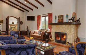 a living room with a fireplace and blue furniture at 12 Bedroom Stunning Home In La Granada De Ro-tint in La Granada de Río Tinto