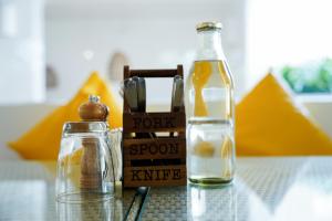 a bottle of fork and spoon next to a bottle of syrup at Bloom Hotel - Calangute in Calangute