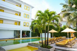卡兰古特Bloom Hotel - Calangute的酒店拥有游泳池、躺椅和棕榈树