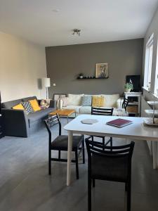 uma sala de estar com uma mesa e um sofá em Varmi Guesthouse Apartments & rooms em Hveragerði