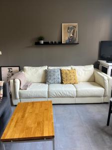 a white couch in a living room with a coffee table at Varmi Guesthouse Apartments & rooms in Hveragerði