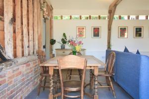 a dining room with a wooden table and chairs at Gull Farm Barn in Burgh