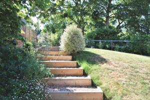 a set of stairs in a garden with bushes at Gull Farm Barn in Burgh