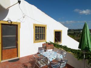 Un patio con mesa y sillas y un edificio. en Casa da Marina, en Aljezur