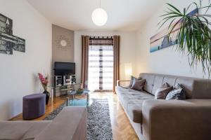 a living room with a couch and a tv at Apartmani Jelena in Omiš