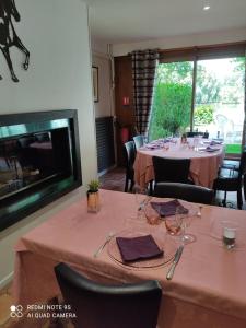 a dining room with a table with chairs and a fireplace at Hostellerie de Pavillon Saint-Hubert in Gouvieux