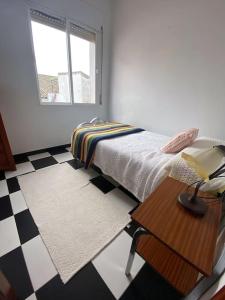 a bedroom with a bed and a table and a window at Casa Cumbres in Cumbres de San Bartolomé