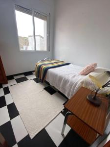 una camera da letto con un letto, un tavolo e una finestra di Casa Cumbres a Cumbres de San Bartolomé