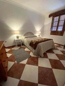 a bedroom with a bed and a checkered floor at Casa Cumbres in Cumbres de San Bartolomé