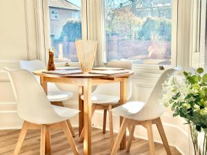 una sala da pranzo con tavolo in legno e sedie bianche di Cliffords Reach at Bluebridge Court -City Centre - Free Parking a York