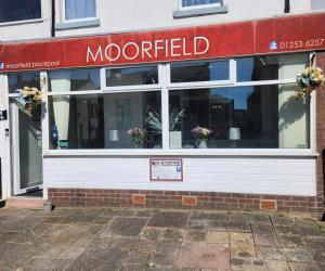 a storefront of a restaurant with a sign in the window at The Moorfield in Blackpool