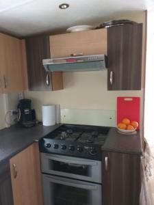 a kitchen with a stove and a bowl of oranges at KERLANN****MOBIL-HOME 4 CH TOUT CONFORT in Pont-Aven +3 photos