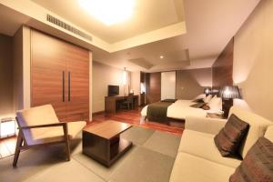Habitación de hotel con cama y sofá en FOURTREAT plus NASUKOGEN en Nasu