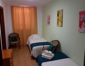 a room with two beds and a table with towels at Portal 17 Can Tort in Tossa de Mar