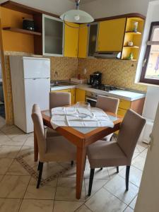 cocina con mesa, sillas y armarios amarillos en Apartment Danica, en Ljubač