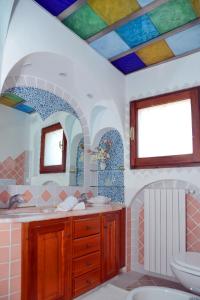 bagno con soffitto colorato e lavandino di Case Vacanze La Conia a Cannigione