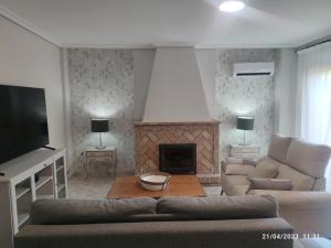 uma sala de estar com um sofá e uma lareira em Los Cipreses em Córdoba