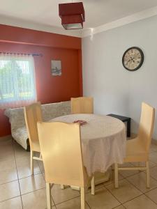 a dining room with a table and chairs and a clock at Apartment QUINTA DE AREIAS in Crespos