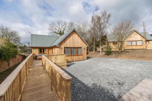 a house with a wooden fence and a wooden walkway at Osprey Lodge 1 with Hot Tub in Newton Stewart