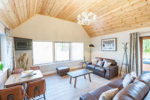 a living room with a couch and a table at Osprey Lodge 1 with Hot Tub in Newton Stewart