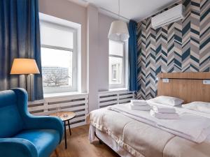 波兹南Hotel Traffic Poznań Stare Miasto的一间卧室，有一张床和一把蓝色椅子
