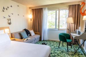 a hotel room with a bed and a couch at Demeures de Campagne Chemins de Sologne à Orléans in Orléans