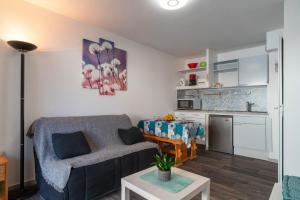 a living room with a couch and a table at Ti Kréol - 5 minutes des plages in Saint-Nic