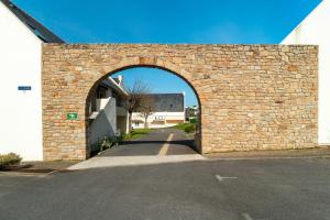an archway in a brick wall next to a street at Ti Kréol - 5 minutes des plages in Saint-Nic