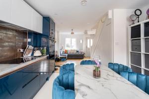a kitchen with a marble table and blue chairs at Monalychee in London