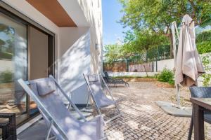 a patio with chairs and a table and an umbrella at Poço do Bispo By ALGARTUR in Tavira