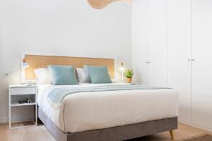 a bedroom with a large bed with blue pillows at Magno Apartments Castelar in Seville