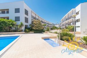 a swimming pool in front of a building at Poço do Bispo By ALGARTUR in Tavira