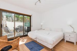 a white bedroom with a bed and a table and chairs at Poço do Bispo By ALGARTUR in Tavira +29 photos