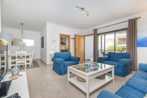 a living room with blue chairs and a table at Poço do Bispo By ALGARTUR in Tavira