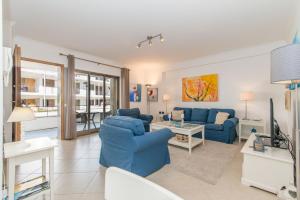 a living room with two blue couches and a table at Poço do Bispo By ALGARTUR in Tavira