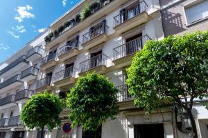 um prédio de apartamentos com árvores em frente em Magno Apartments Castelar em Sevilha