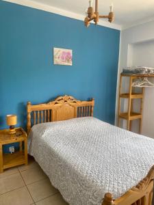 1 dormitorio con cama y pared azul en Apartment QUINTA DE AREIAS, en Crespos