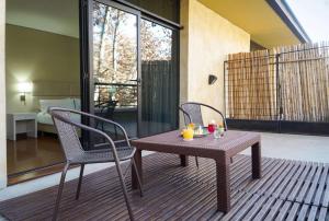 un patio con mesa, 2 sillas y 1 cama en NH Mendoza Cordillera en Mendoza