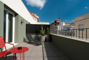 a balcony with a red table and chairs on a building at chic&basic dot in Madrid +53 photos