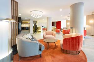 a lobby with two couches and a table and chairs at NH Madrid Balboa in Madrid