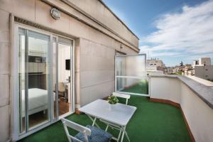 - un petit balcon avec une table et des chaises dans un bâtiment dans l'établissement NH Madrid Balboa, à Madrid