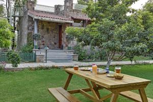 a wooden picnic table with a candle on it in a yard at Vatsalya Vihar - A Luxury Pool Villas Resort in Udaipur