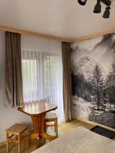 a bedroom with a table next to a window at Pokoje Gościnne Stanek in Zakopane