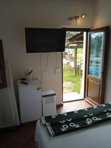 Pokój z telewizorem na ścianie i lodówką w obiekcie Lo Stazzo w mieście Aggius