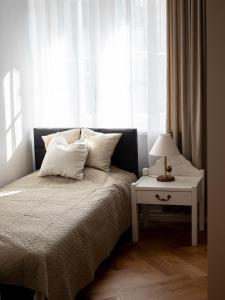 a bedroom with a bed and a table with a lamp at Meissneri villa in Kuressaare
