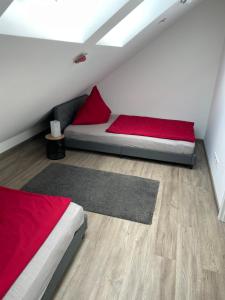 um quarto com 2 camas com lençóis vermelhos e um tapete em Haus Schloßblick em Reichenberg