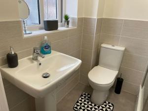 ein Bad mit einem Waschbecken und einem WC in der Unterkunft Fresh & Spacious New Build Home in Church Coppenhall
